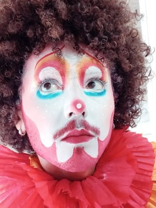 Personagem com maquiagem de palhaço e gola vermelha