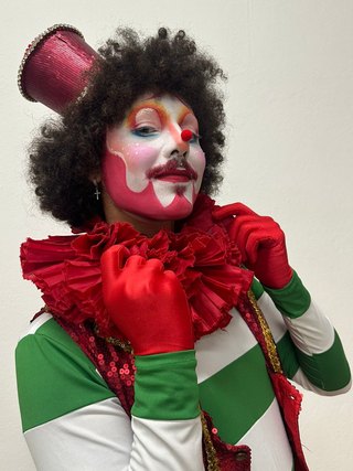Personagem de cartola, luvas vermelhas e figurino verde